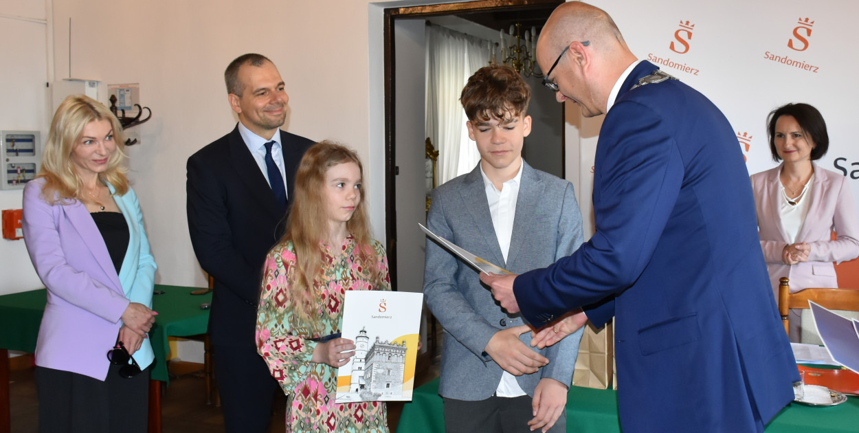 Helena i Seweryn Fołtowie odbierają dyplom z rąk burmistrza Pawła Niedźwiedzia. 