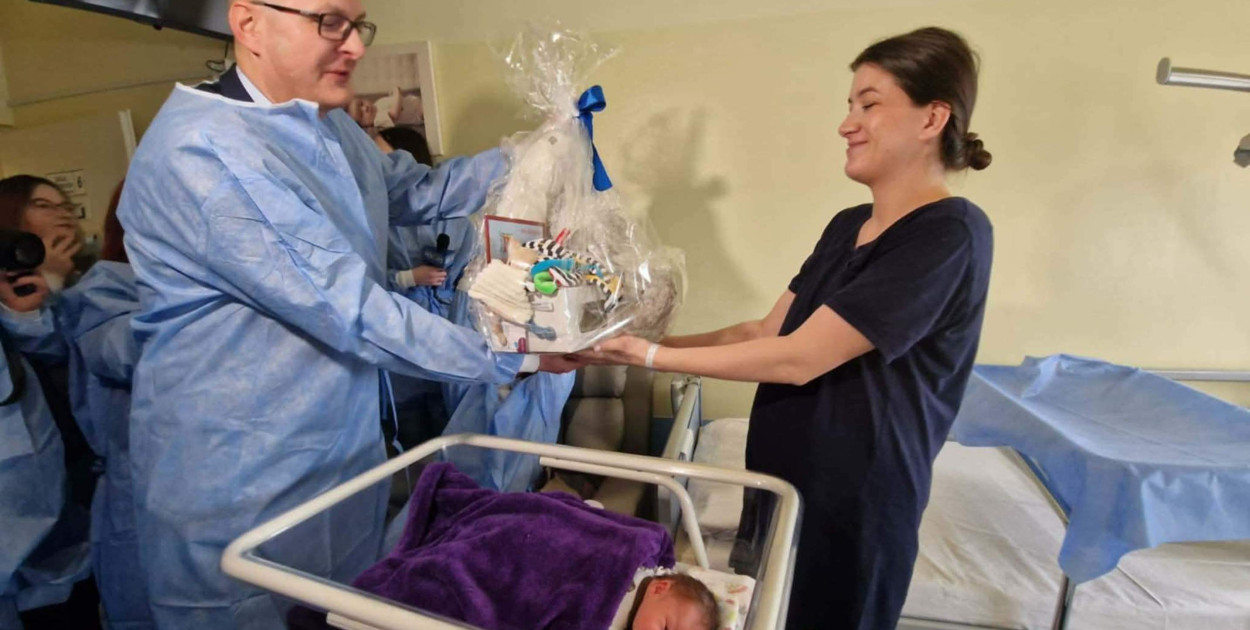 Pani Klaudia, mama Juliana, odbiera prezent od burmistrza Pawła Niedźwiedzia.   